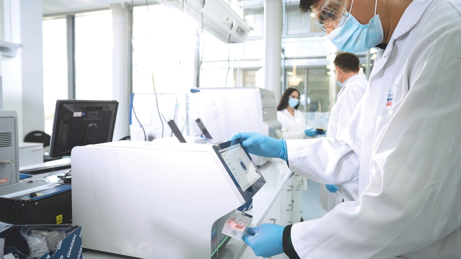 Diagnostic testing equipment appears in a laboratory image supplied by QIAGEN.