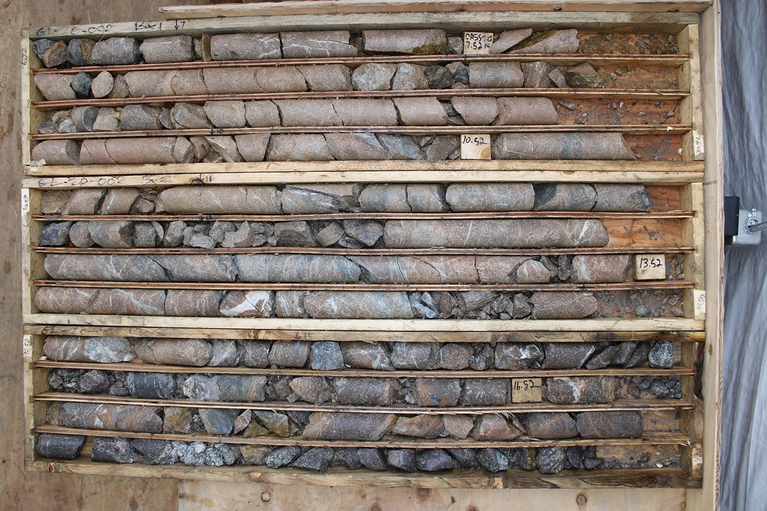 A wooden tray holds rows of drill core from Evergold's Golden Lion project gallery.