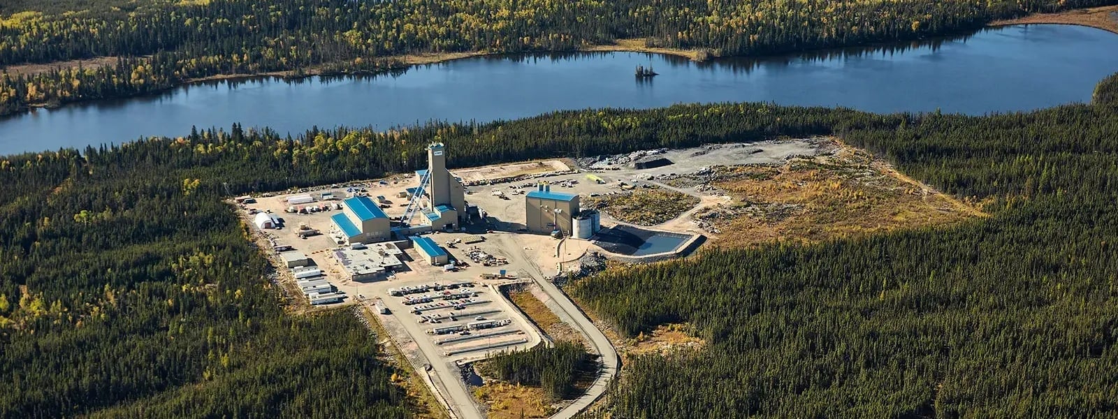 An aerial photograph shows Hudbay's Lalor mine buildings beside dense forest in Manitoba.