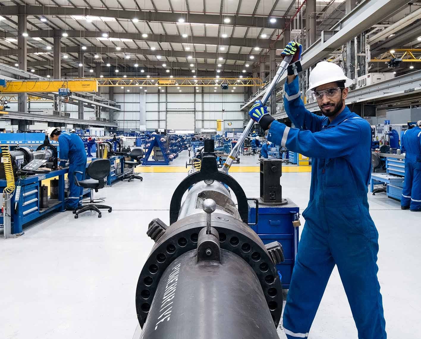 A worker assembles industrial equipment in a manufacturing facility.