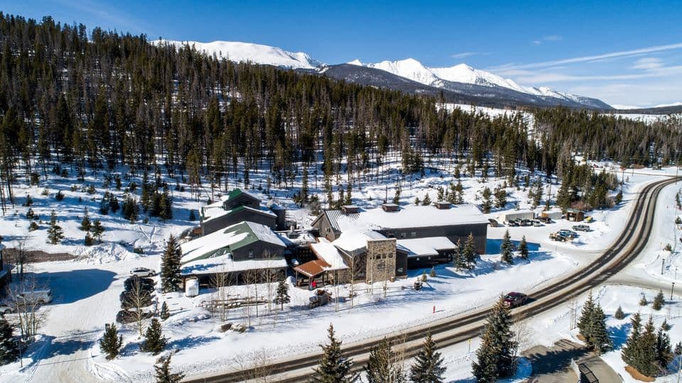 Colorado's breckenridge distillery with snow on the roof and snow covered mountains in the background