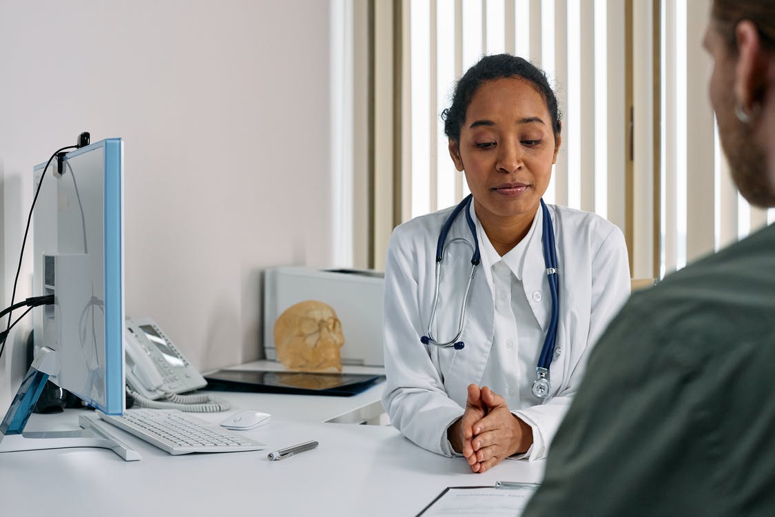 Doctor sitting across a table from a patient during a consultation