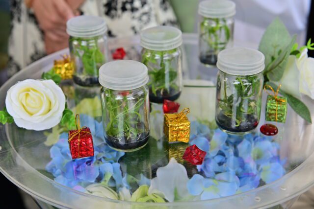 Cannabis leaves in jars on a table with flowers